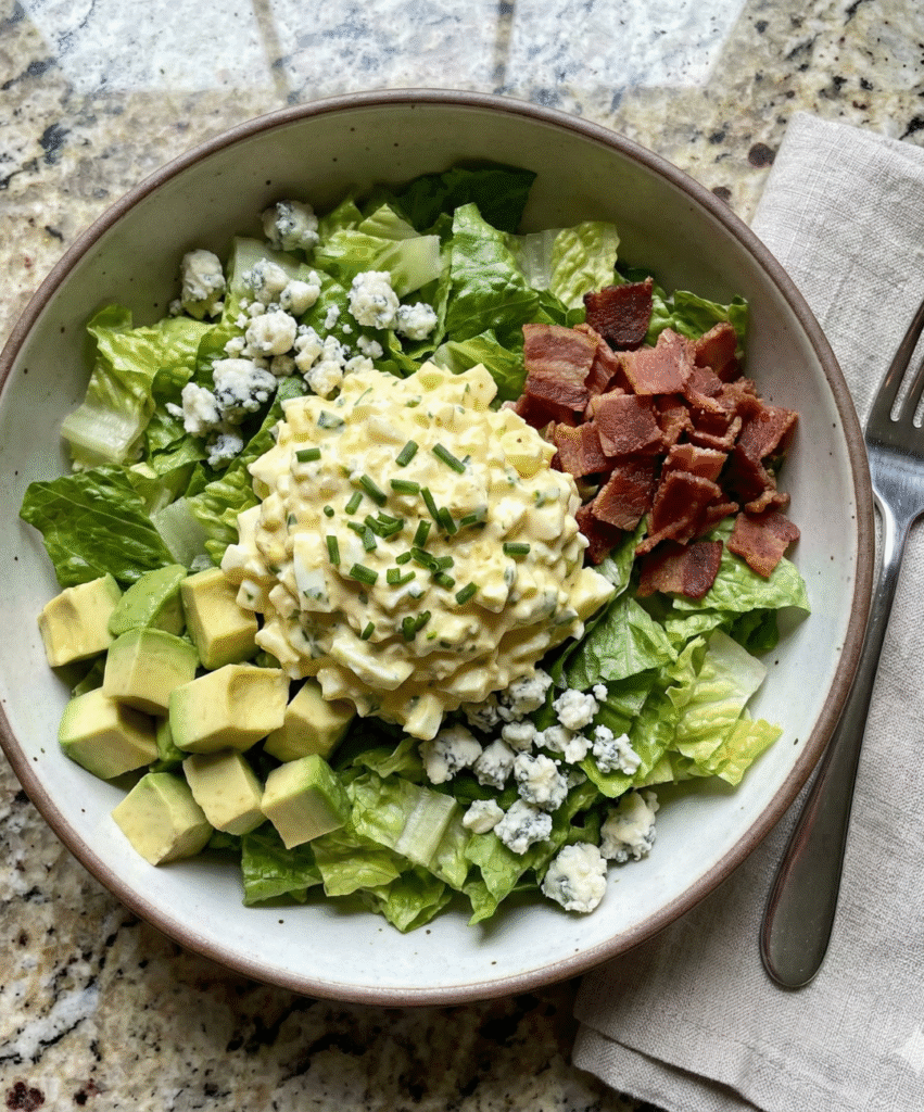 cobb egg salad bowl with romaine lettuce, avocado, bacon, and blue cheese crumbles