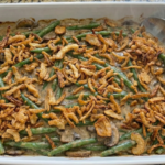 Homemade green bean casserole in a white baking dish topped with golden crispy onions
