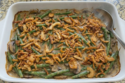 Homemade green bean casserole in a white baking dish topped with golden crispy onions